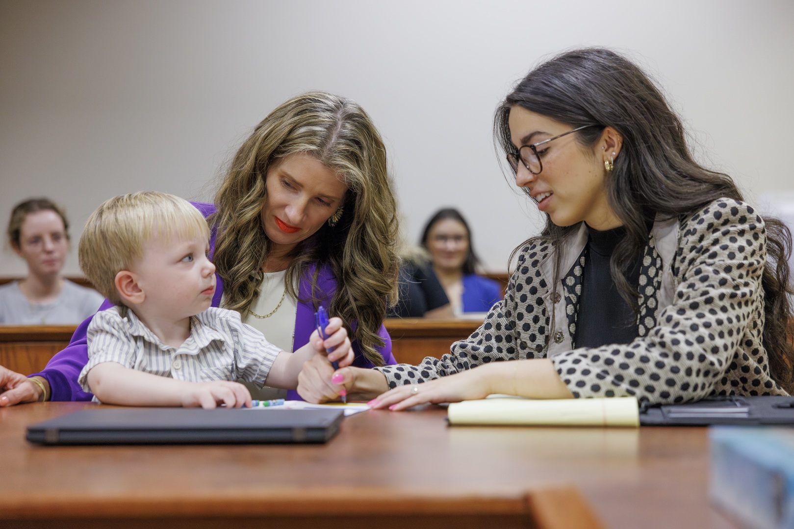 Attorneys in courtroom speaking with child client